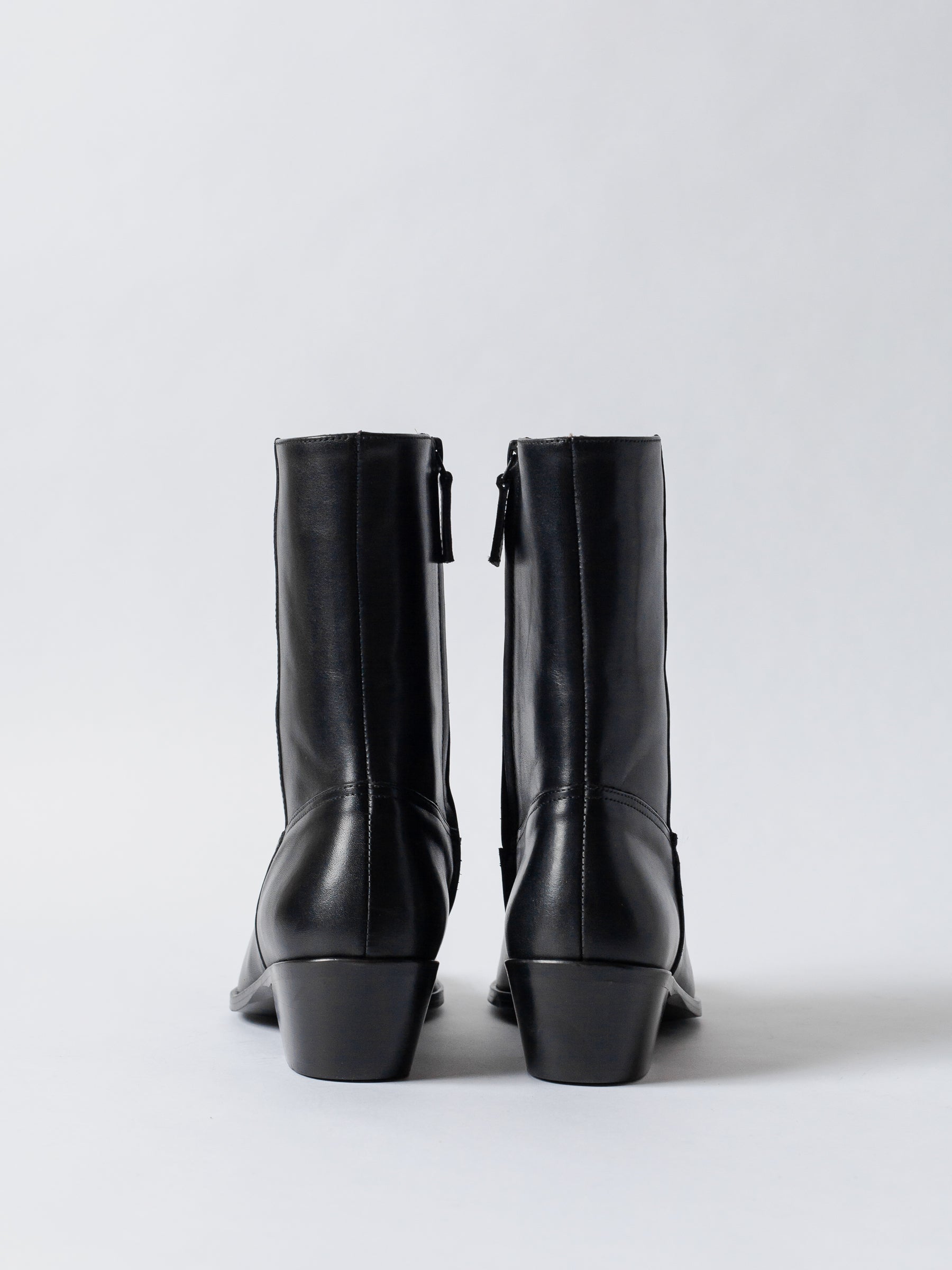 Pair of black leather boots on a white background