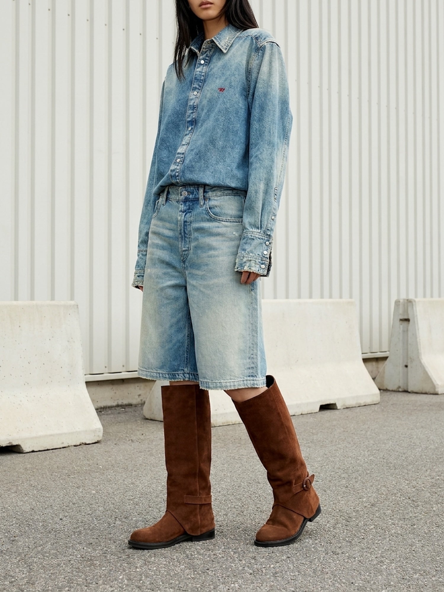 Person wearing a denim outfit with knee-high brown boots in an urban setting.